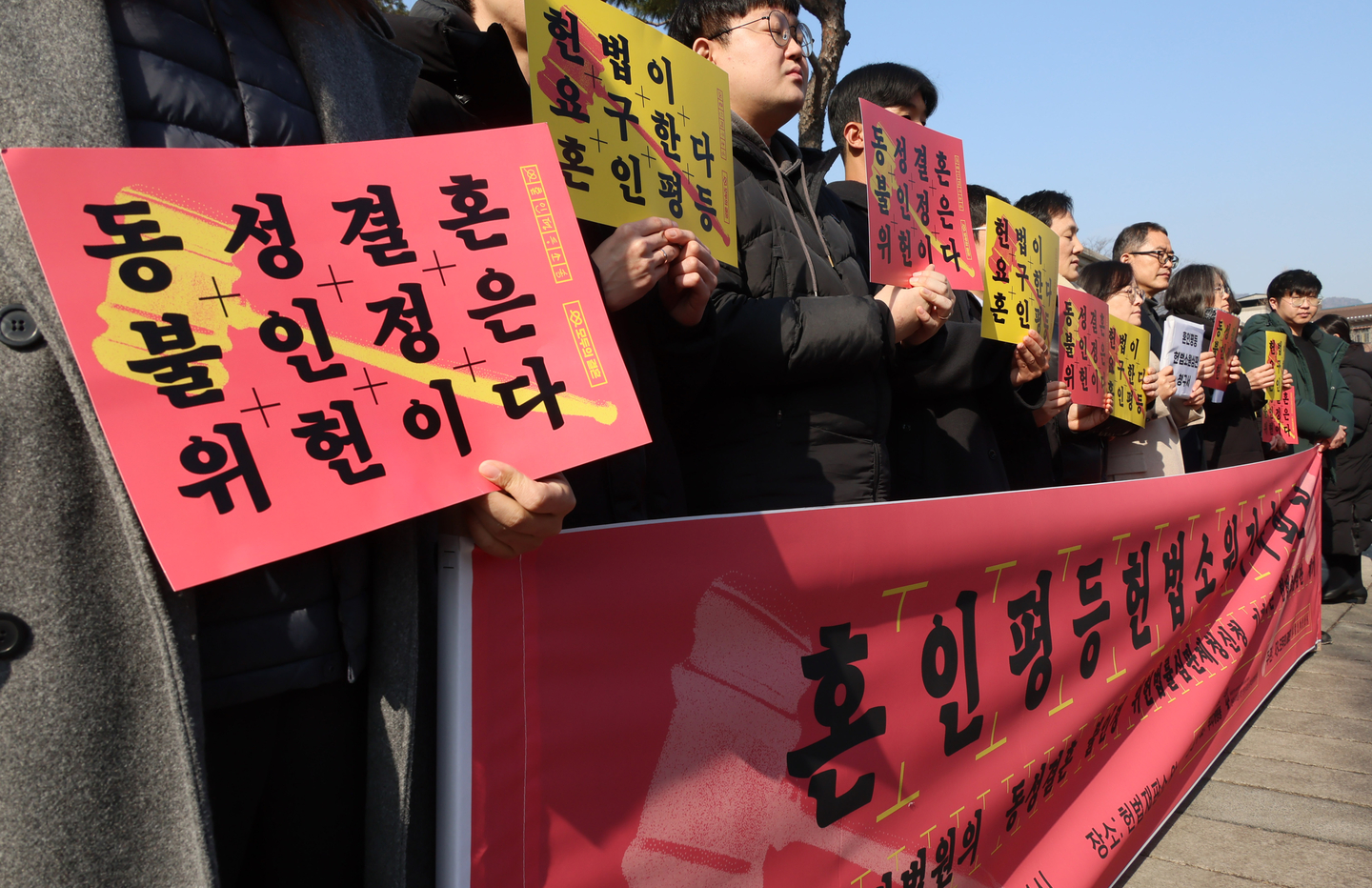Members of same-sex marriage equality group Rainbow Action Korea and Minbyun Lawyers for a Democratic Society hold a press conference outside the Constitutional Court in Jongno District, central Seoul, on Feb. 14, to file a constitutional petition following a Seoul Northern District Court decision rejecting a request for a constitutional review on the nonrecognition of same-sex marriage. [YONHAP]