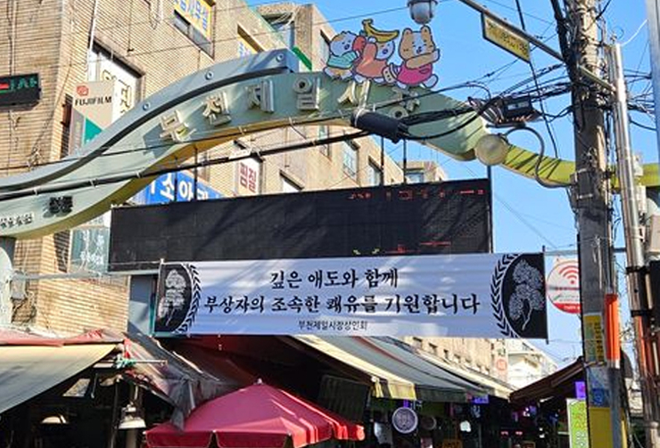 This photo shows a banner at the entrance of a traditional market in Bucheon, Gyeonggi, on Nov. 16. The banner expresses condolences and well wishes for the victims of the recent truck accident. [MOON SANG-HYEOK]