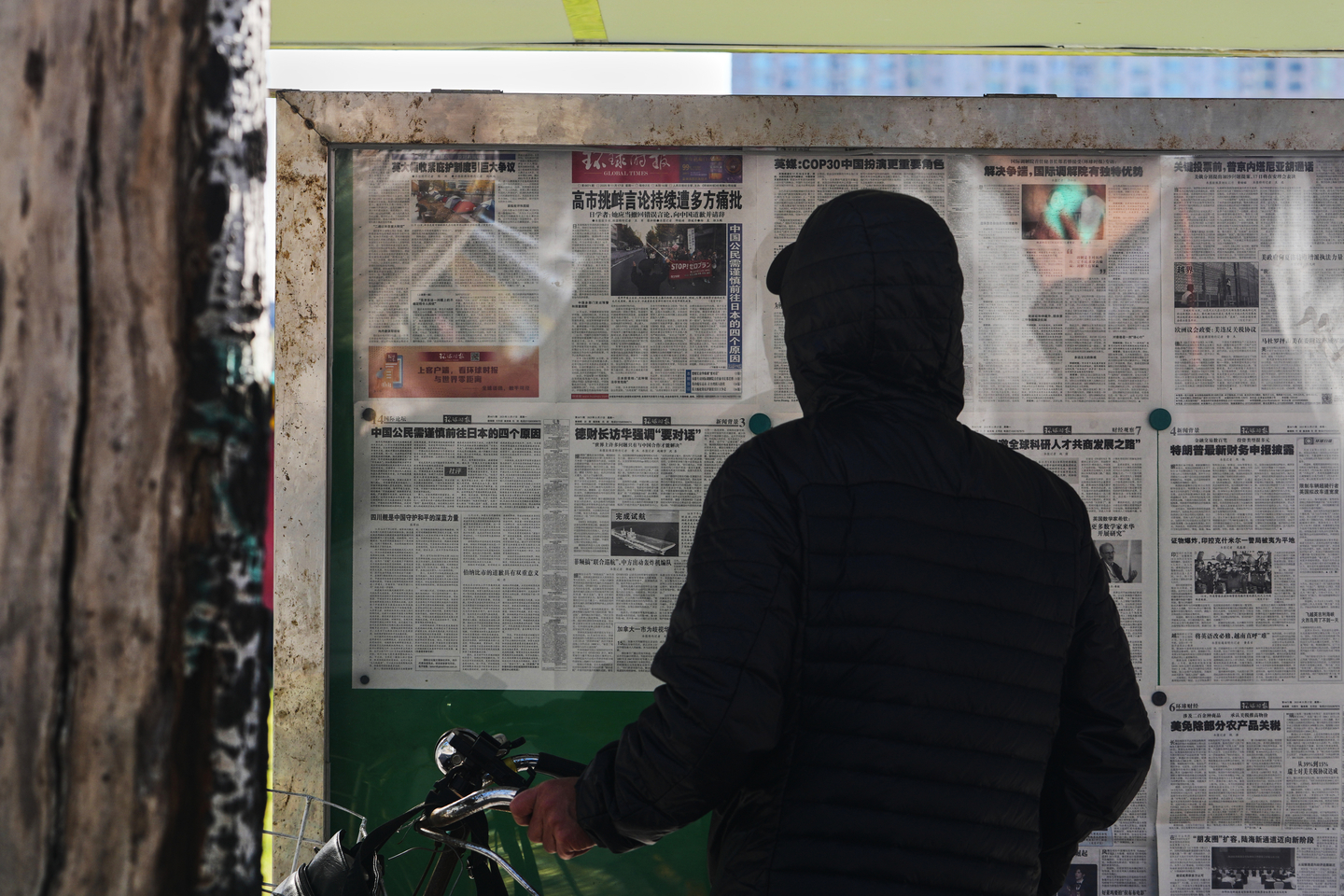 A passerby reads local newspapers reporting on Japanese Prime Minister Sanae Takaichi's recent remarks on Taiwan at a newsstand in Beijing on Nov. 17. [AP/YONHAP] 
