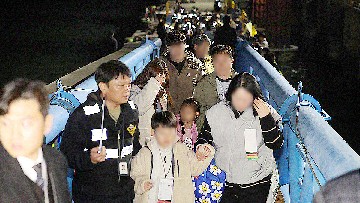 Passengers aboard the ferry Queen Jenuvia II are being led off the deck by officials from the Mokpo Coast Guard after the ferry ran aground on Nov. 19. [YONHAP]