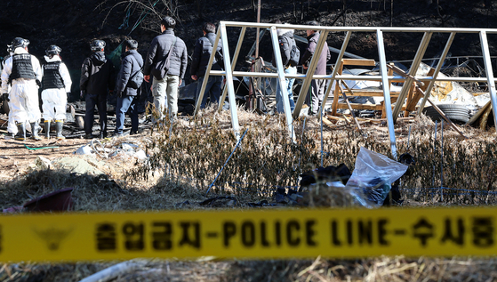 Fire and police investigators examine the suspected ignition point of a wildfire in Girin-myeon, Inje County, Gangwon, on Nov. 21. [NEWS1]