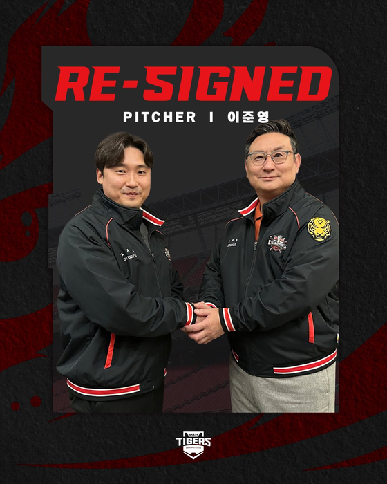 Kia Tigers pitcher Lee Jun-young, left, shakes hands with general manager Shim Jae-hak after signing a new three-year contract with the club on Nov. 23. [SCREEN CAPTURE] 