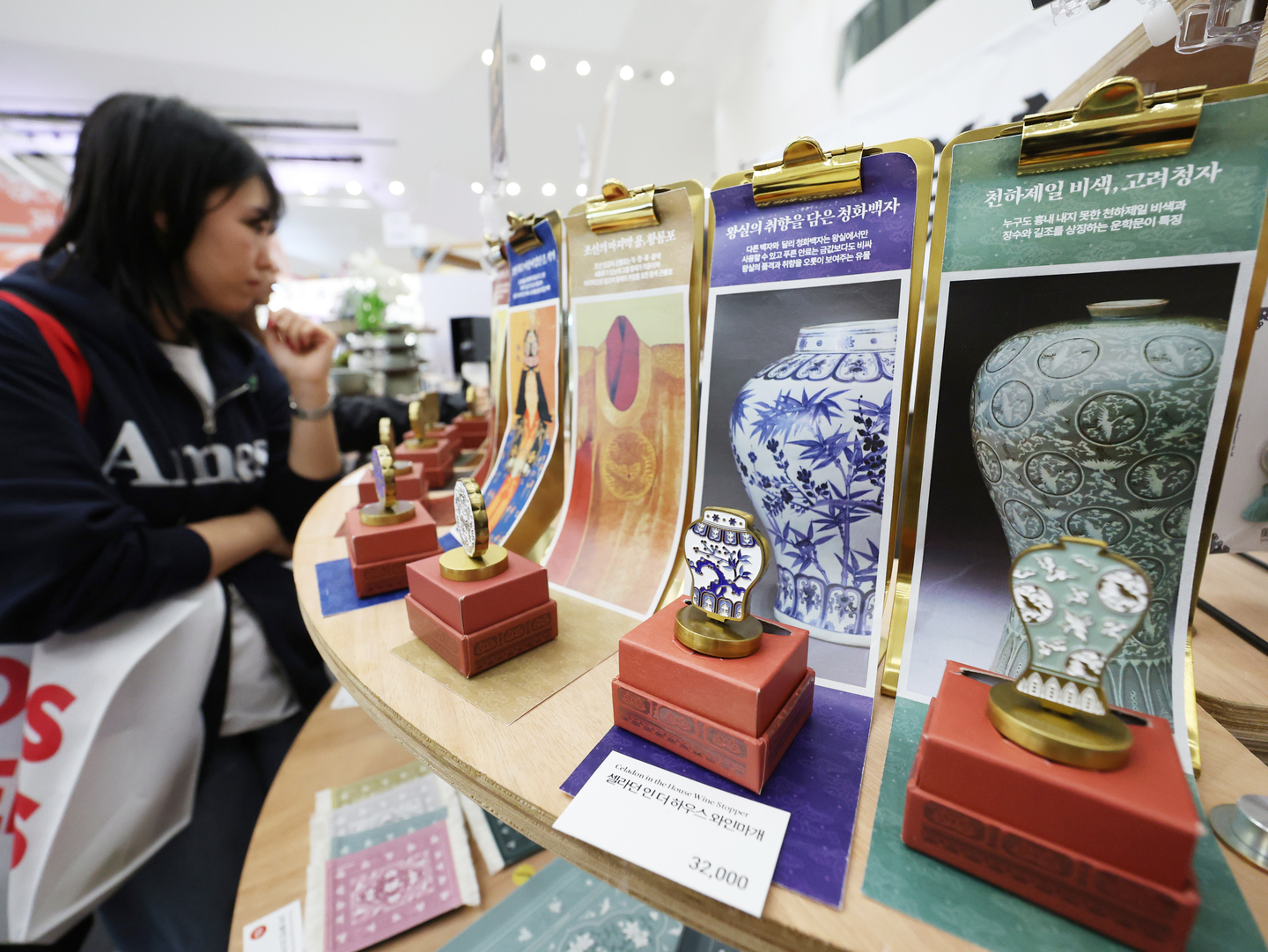Visitors look at wine stoppers inspired by traditional vases of the Joseon Dynasty (1392-1910) at 2025 The Souvenir Fair at Dongdaemun Design Plaza in central Seoul on Nov. 23. [YONHAP]