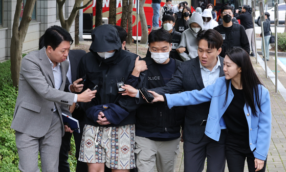 A suspect extradited from Cambodia enters a courtroom at the Daejeon District Court’s Hongseong Branch in South Chungcheong for a pretrial detention hearing on Oct. 20. [NEWS1]