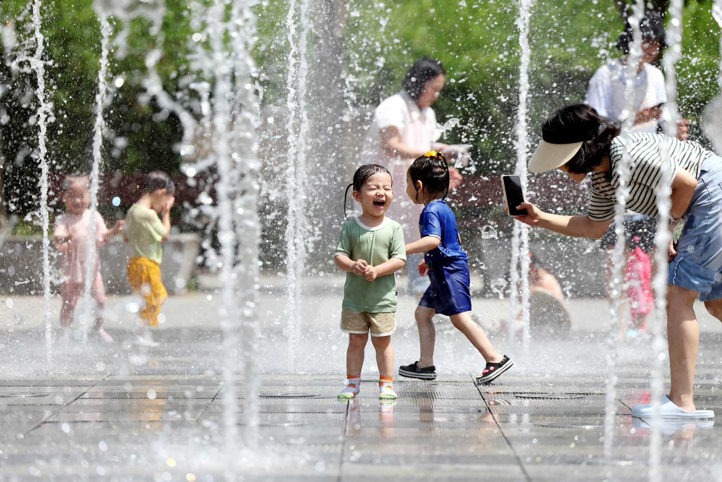 Children are seen playing in a fountain in a park in Gwangju on July 2. [YONHAP]