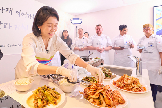 First lady Kim Hea Kyung, left, serves Korean food during a cooking event at the Korean Cultural Center in Johannesburg, South Africa, on Nov. 22. [JOINT PRESS CORPS] 