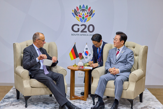 President Lee Jae Myung, right, and German Chancellor Friedrich Merz talk during a summit at the Johannesburg Expo Centre in Johannesburg, South Africa on Nov. 22. [JOINT PRESS CORPS]