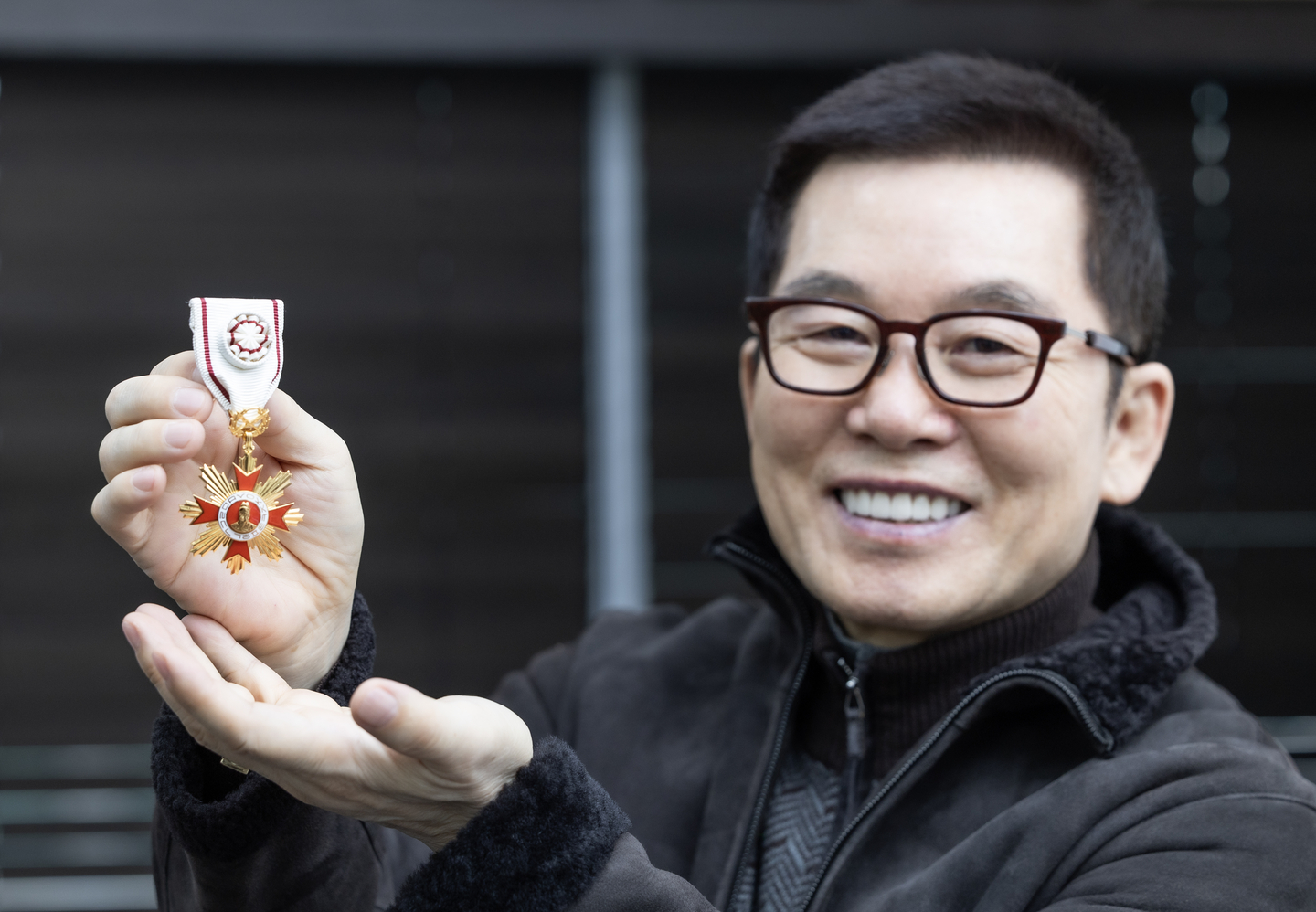 Choi Sin-gyu poses with his Hwagwan Order of Culture Merit badge, given by the Ministry of Culture, Sports and Tourism, during an interview with the JoongAng Ilbo at Choi Creative Lab’s office in Mok-dong, Yangcheon District, western Seoul, on Nov. 20. [KWEN HYEK-JAE]