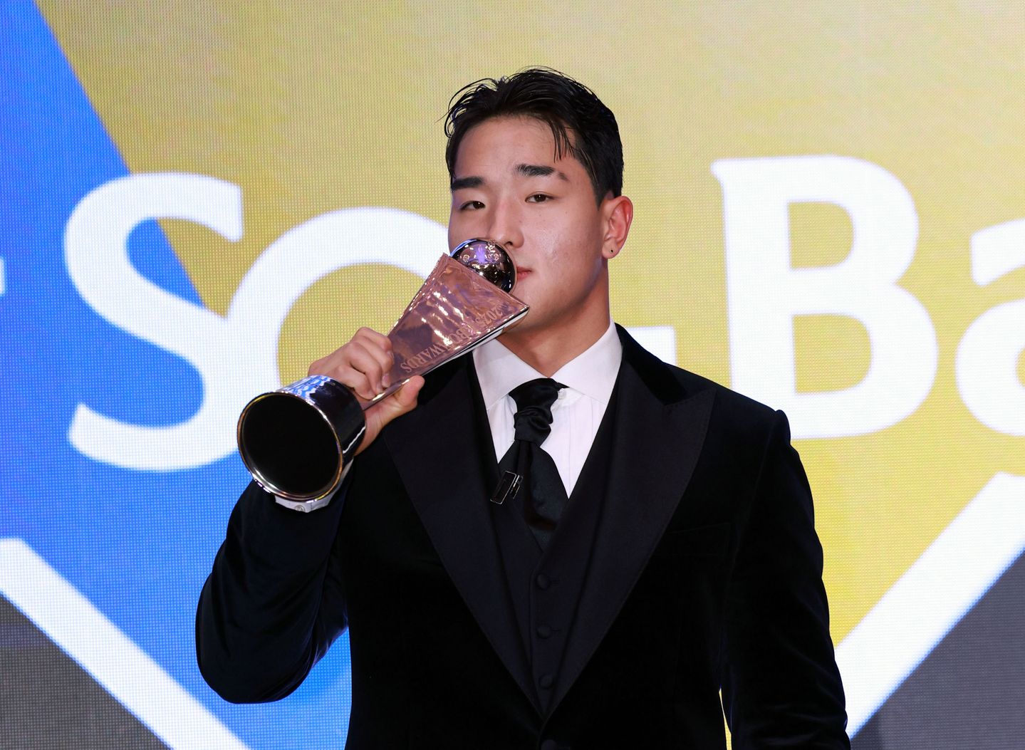 KT Wiz outfielder Ahn Hyun-min kisses his trophy after winning Rookie of the Year at the 2025 Shinhan SOL Bank KBO Awards at Lotte Hotel World in Seoul on Nov. 24. [YONHAP]