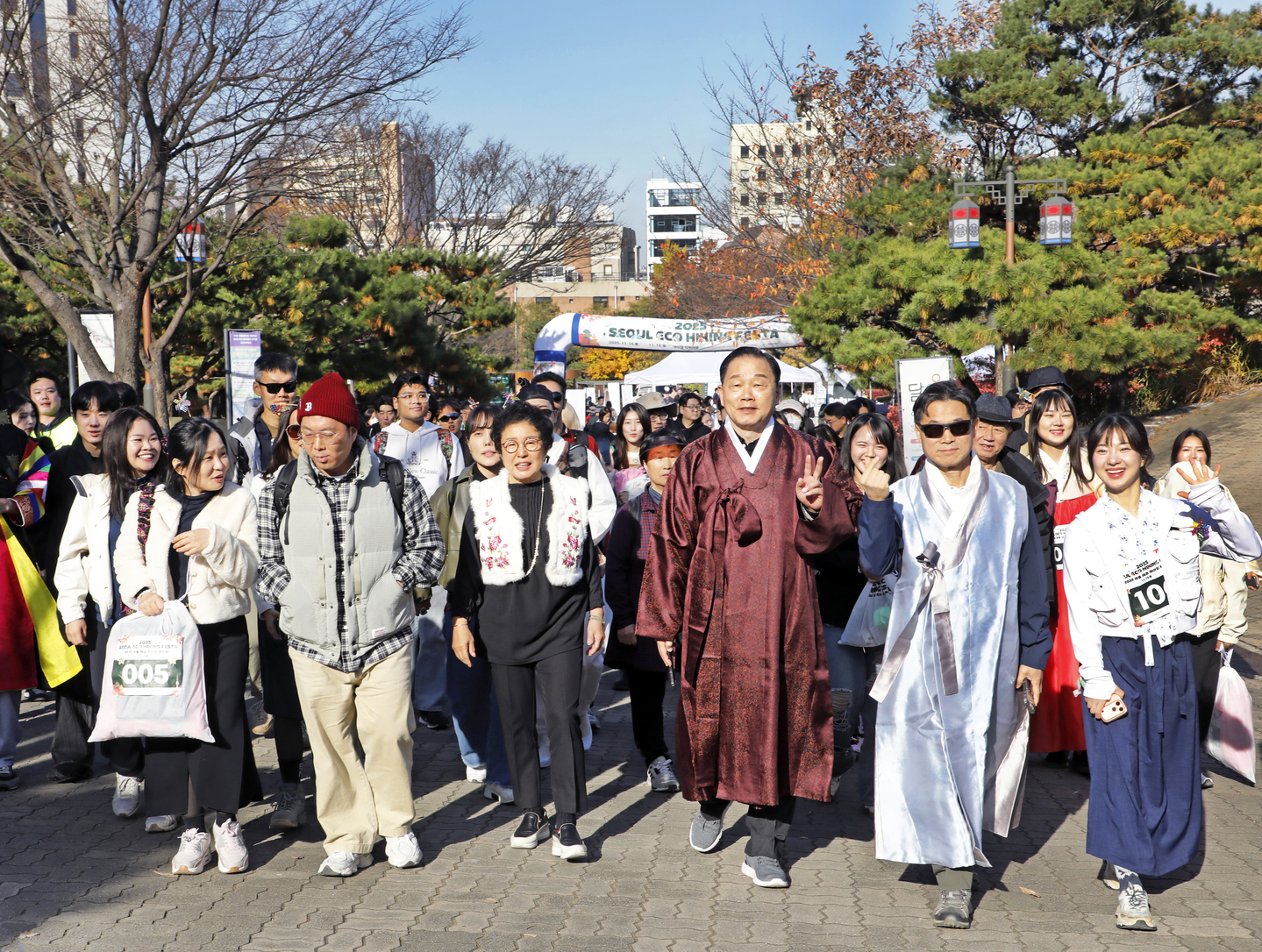 Kil Ki-yon, CEO and president of Seoul Tourism Organization, front row, third from right, Lee Soo-taek, executive director of tourism industry division at Seoul Tourism Organization, second from right, Cho Tae-sook, president of Seoul Tourism Association, fourth from right, and participants of the 2025 Seoul Eco Hiking Festa embark on a hike on Mount Namsan in Jung District, central Seoul, on Nov. 15. [PARK SANG-MOON]