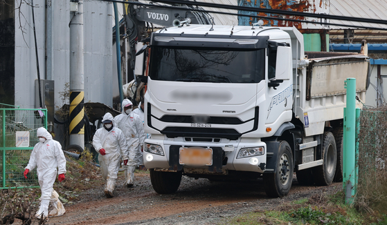 Quarantine workers move quickly through a pig farm in Dangjin, South Chungcheong on Nov. 25. [NEWS1]