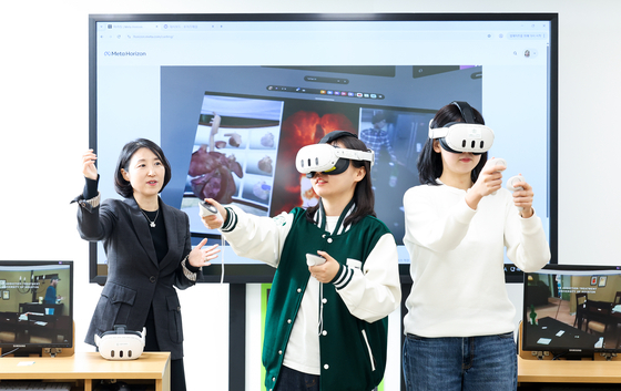 Professor Chun Jong-serl of the Department of Social Welfare at Ewha Womans University, left, demonstrates a virtual reality technology currently being developed in collaboration with the university’s Department of Artificial Intelligence at the Ewha-Samsung Education Culture Building on Nov. 24. [JOONGANG ILBO]