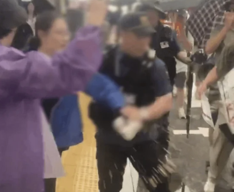 A woman throws coffee at anti-China protesters in central Seoul in a video recorded earlier this month that later circulated widely on social media. [SCREEN CAPTURE]