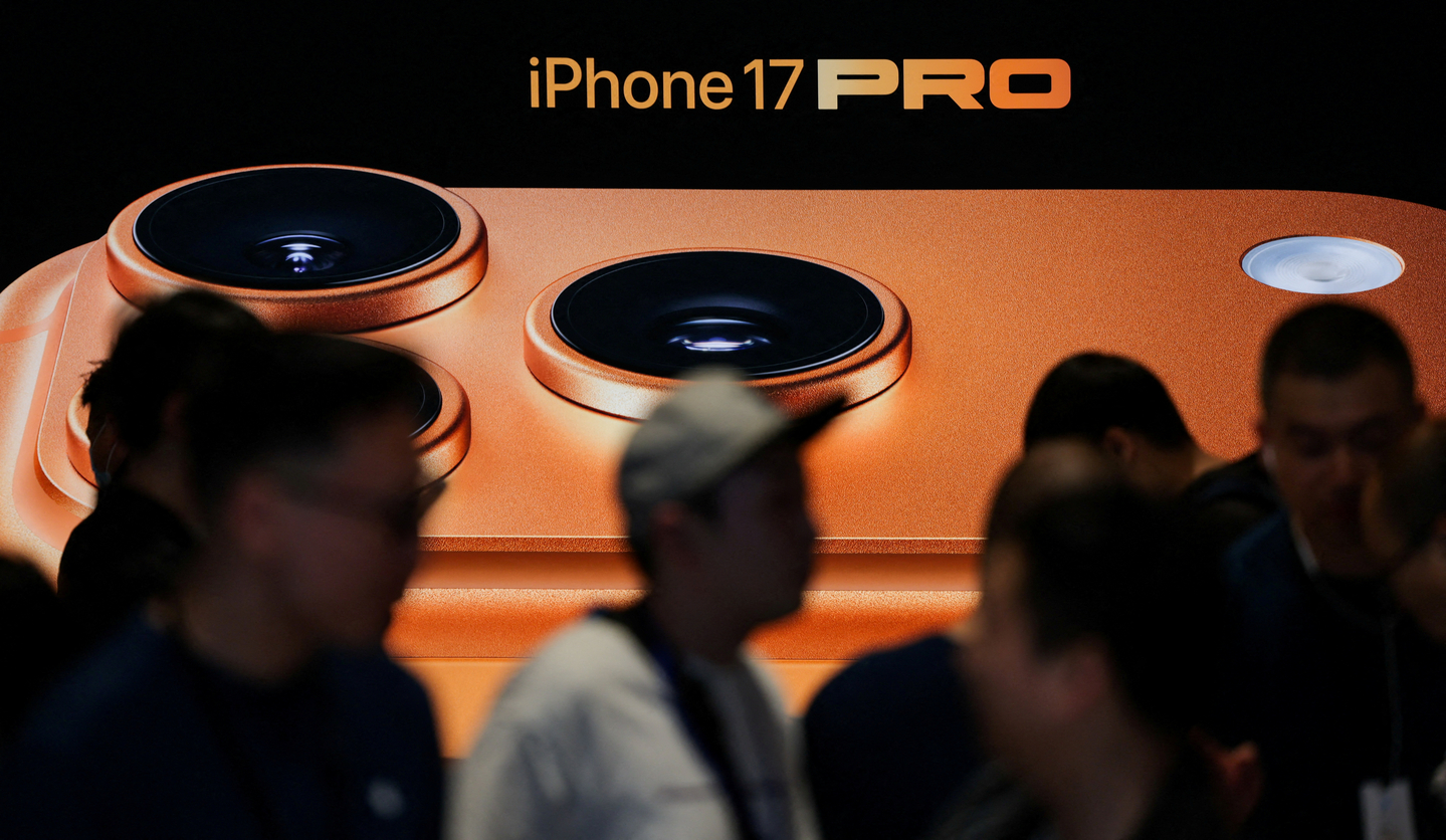 People gather next to an advertisement board at the Apple store in Beijing's Sanlitun area during the start of sales of the new iPhone 17 series smartphones in Beijing, China, on Sept. 19. [REUTERS/YONHAP] 