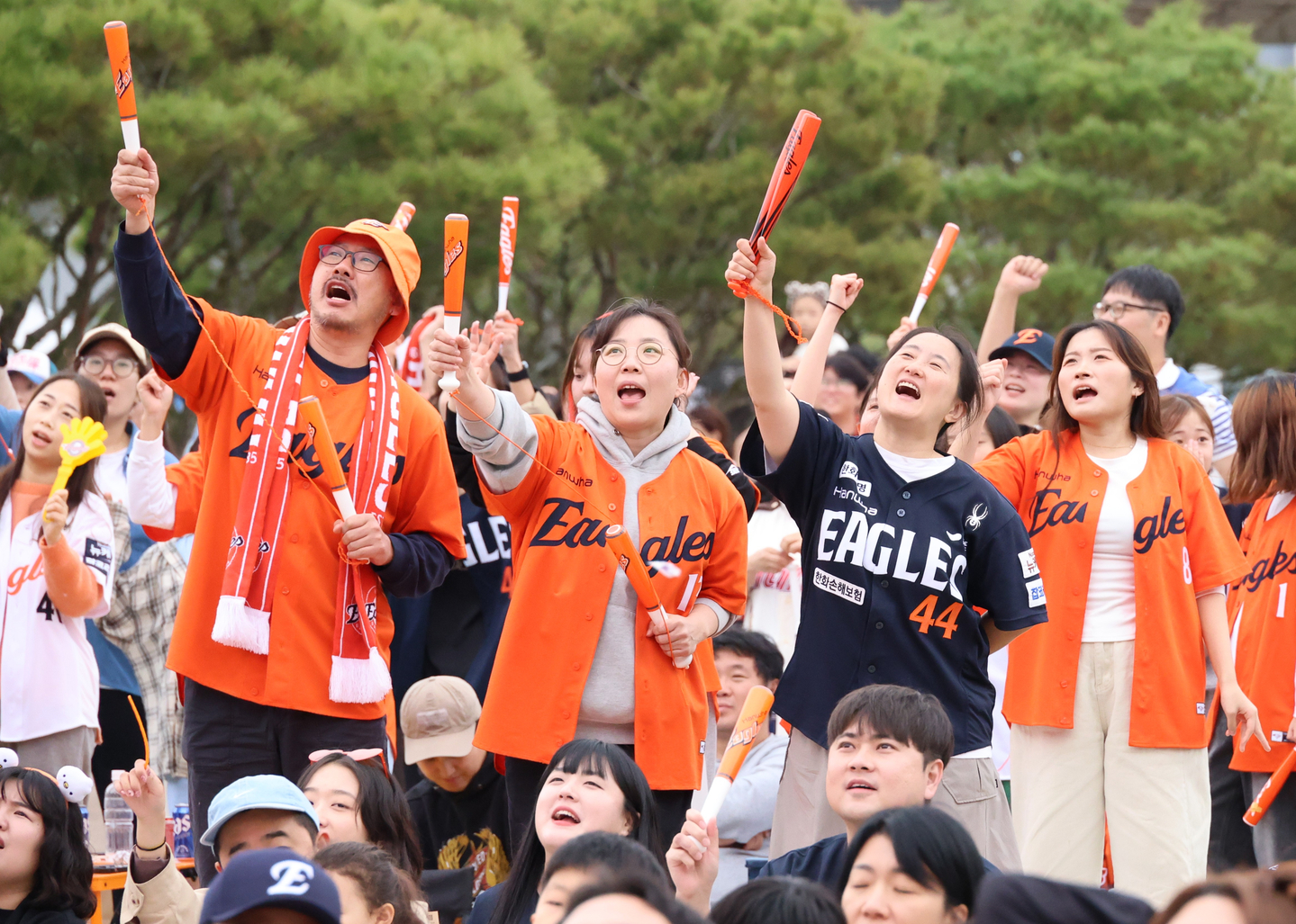 Hanwha Eagles fans cheer while watching the first game of the 2025 KBO postseason playoff series between the Samsung Lions and Hanwha Eagles at the plaza in front of the National Science Museum in Daejeon on Oct. 18. [YONHAP]