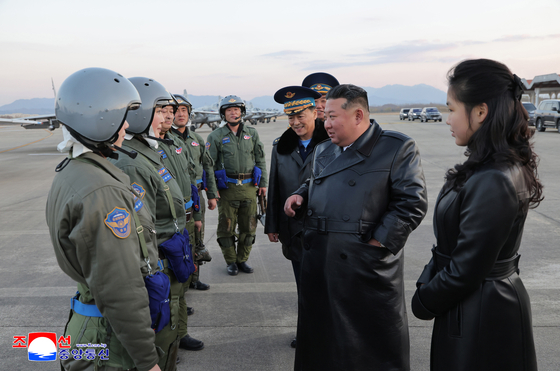 A photo released by the official Korean Central News Agency shows North Korean leader Kim Jong-un, center, and his daughter Kim Ju-ae, right, visiting the Kalma Airport of the 59th Kil Yong Jo Hero Flying Group of the Second Air Wing to mark the 80th founding anniversary of the Korean People's Army Air Force in Pyongyang, North Korea, on Nov. 28. [EPA/YONHAP]