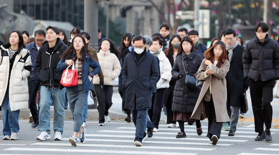 People in heavy winter clothing walk through Gwanghwamun Intersection in central Seoul on Nov. 26. [NEWS1] 