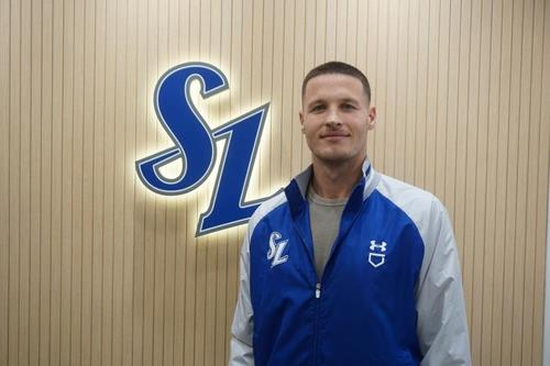 New Samsung Lions pitcher Matt Manning poses in front of the team's logo at Daegu Samsung Lions Park in Daegu on Dec. 1.  [SAMSUNG LIONS] 