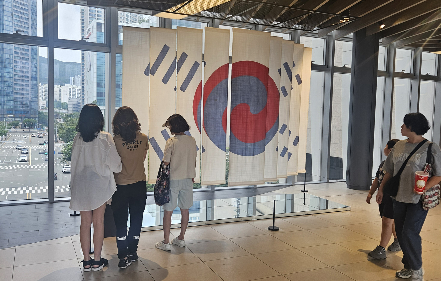 Visitors to the Shinsegae Department Store in Haeundae, Busan look at the ″Denny Taegeukgi″ (1891), initially owned by Owen N. Denny, an American who served as a diplomatic adviser to King Gojong from 1886 to 1890, donated by Denny's descendants to Korea, on display on Constitution Day, July 17. [YONHAP]