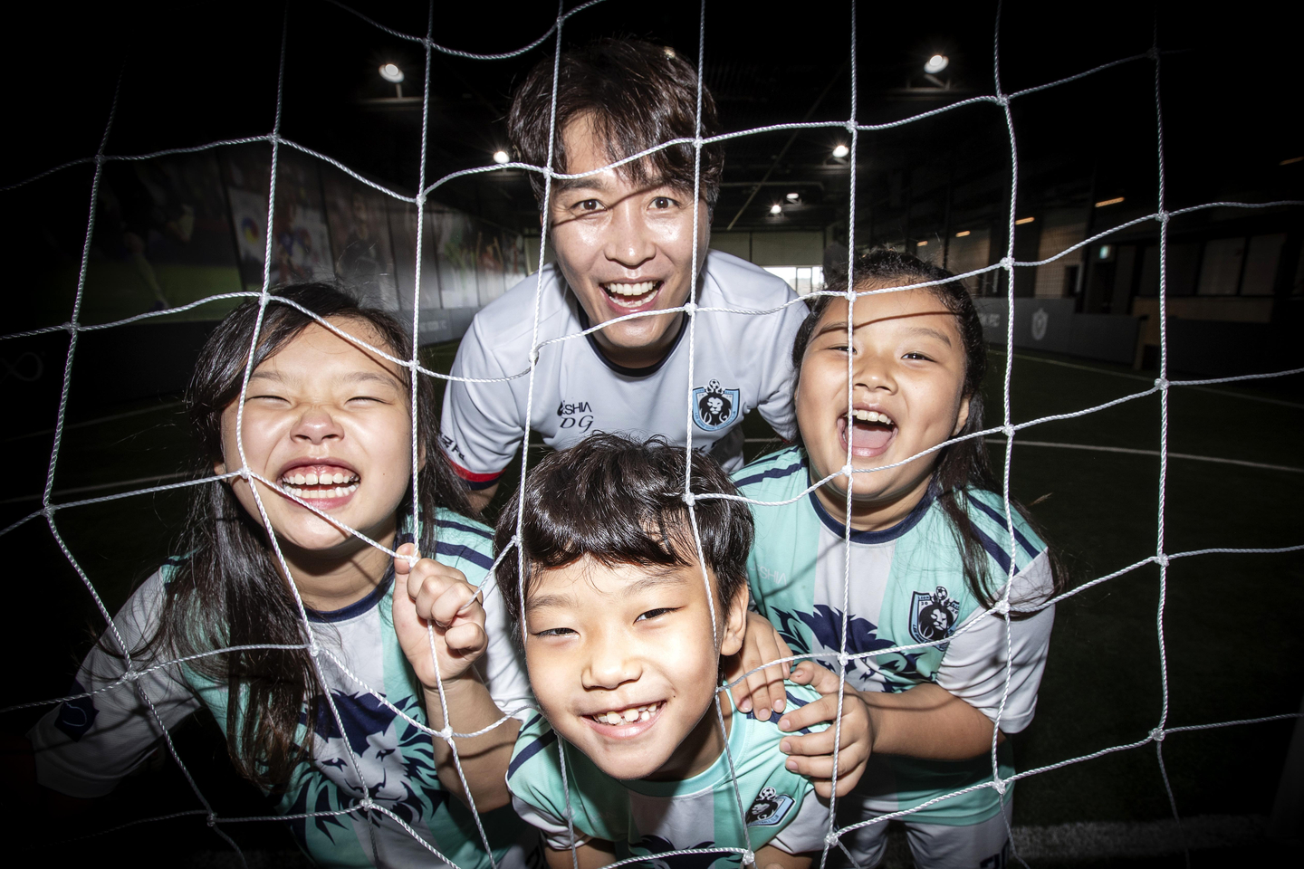 Lee Dong-gook and three of his children smile in front of a football goal.[JOONGANG ILBO]