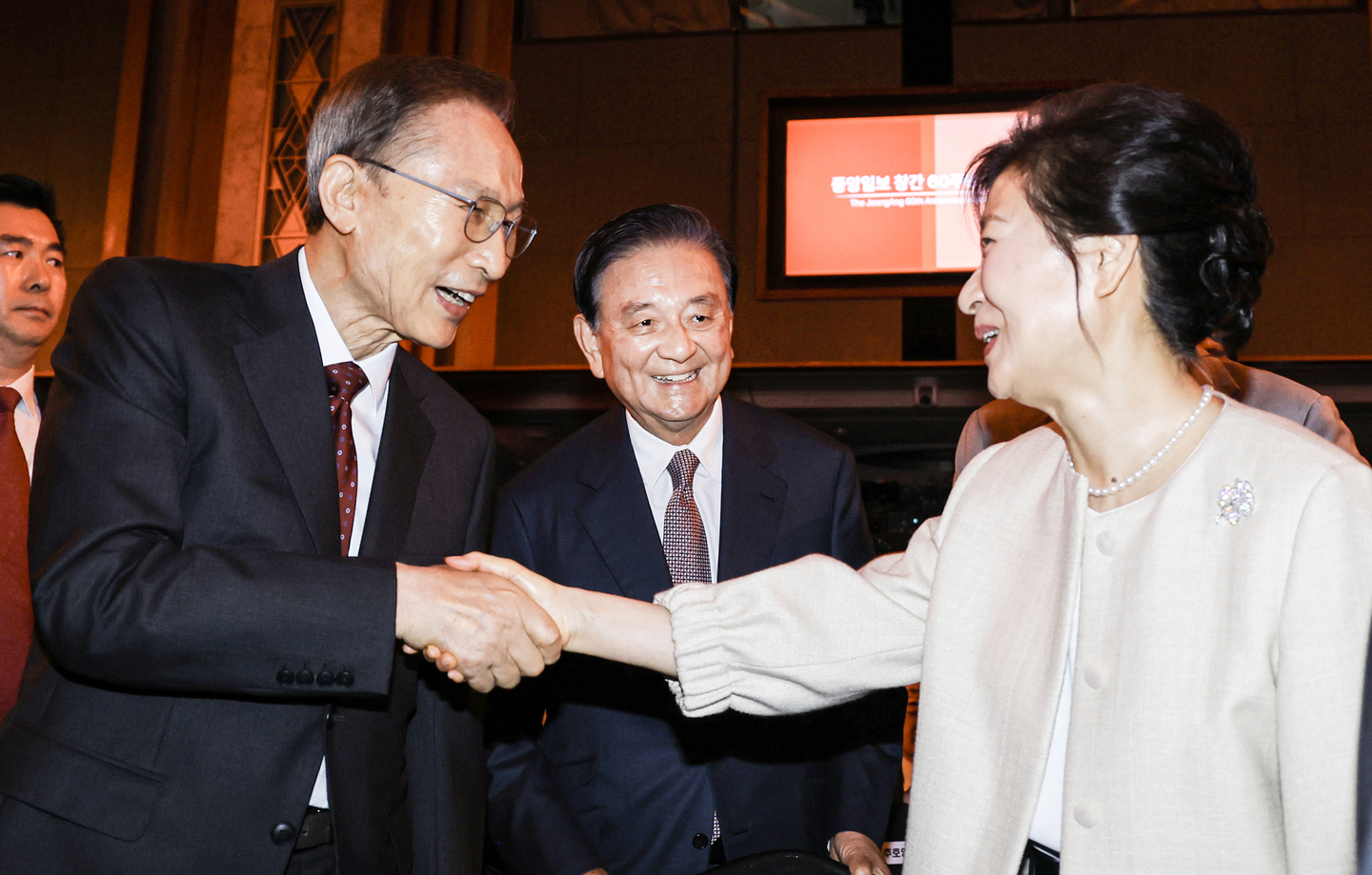 Former Presidents Lee Myung-bak, left, and Park Geun-hye, right, shake hands as JoongAng Holdings Chairman Hong Seok-hyun, center, greets them ahead of the JoongAng Ilbo’s 60th-anniversary ceremony at Lotte Hotel in Jung District, central Seoul, on Sept. 17. [KIM KYUNG-ROK]