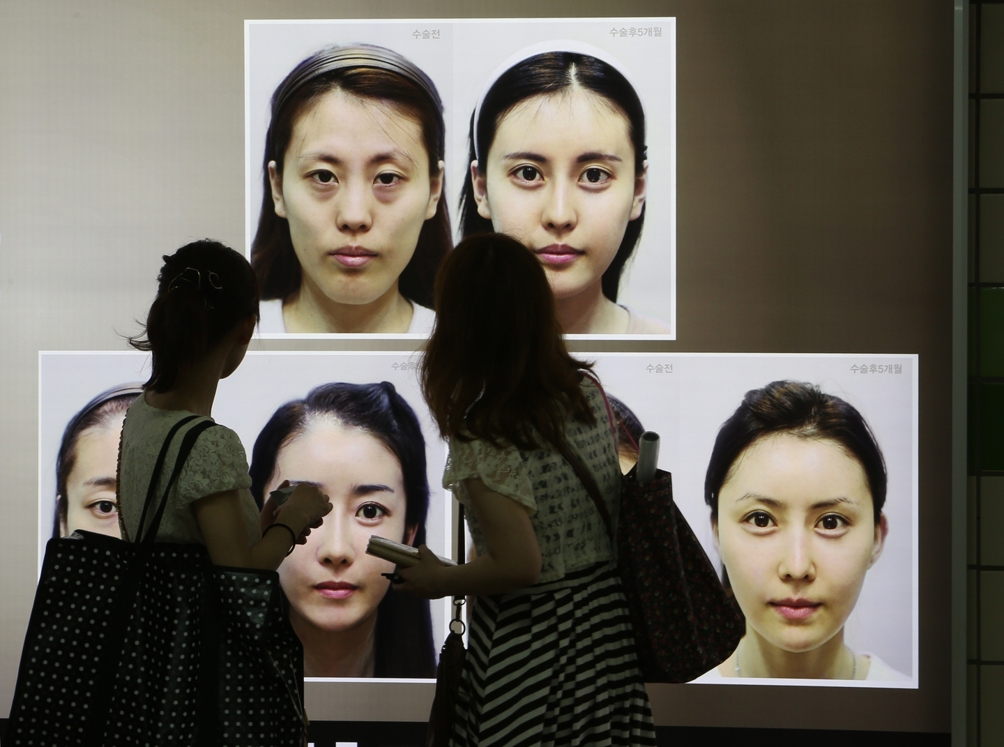 Commuters view cosmetic surgery advertisements in a Seoul subway station on July 26, 2012. [JOONGANG ILBO]