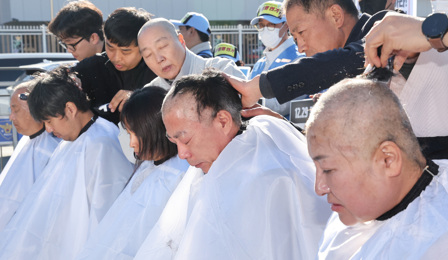 Families of the victims of last year's Jeju Air crash shave their heads in front of the War Memorial of Korea in Yongsan District, central Seoul, on Dec. 1, calling for the suspension of a public hearing by the Aviation and Railway Accident Investigation Board and for the body’s independence. [NEWS1]