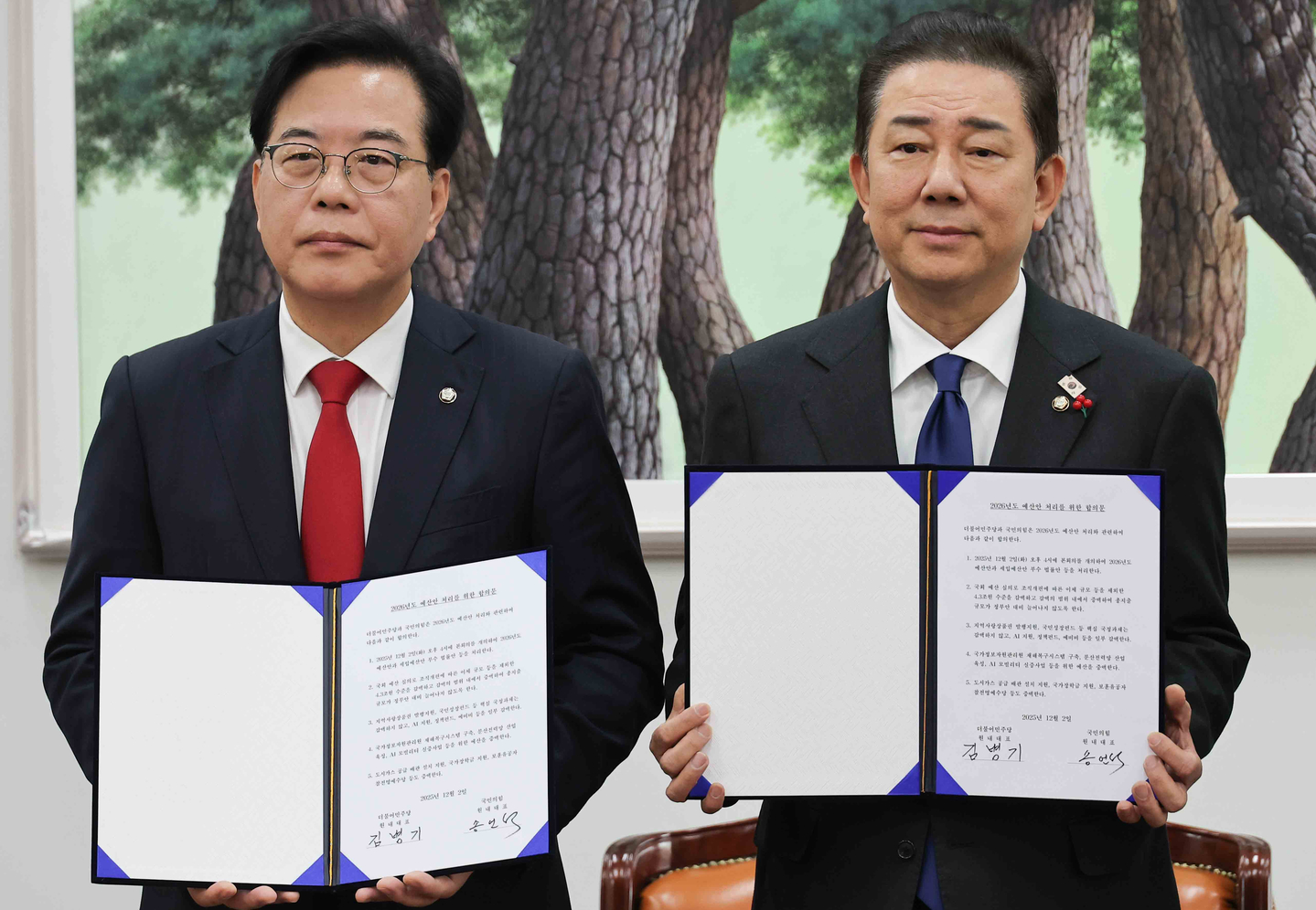 Kim Byung-kee, right, floor leader of the liberal Democratic Party, and Song Eon-seog, floor leader of the conservative People Power Party, pose for a photo at the National Assembly in Seoul on Dec. 2, after the rival parties reached a last-minute deal on next year's national budget and agreed to pass it through parliament the same day, just hours before the legal deadline. [YONHAP]