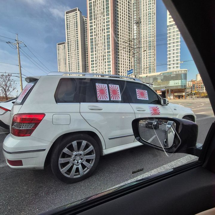 This white Mercedes-Benz SUV adorned with images of the Rising Sun flag, a symbol of Japanese imperialism, was spotted in the middle of a road in Gimpo, Gyeonggi. [SCREEN CAPTURE]