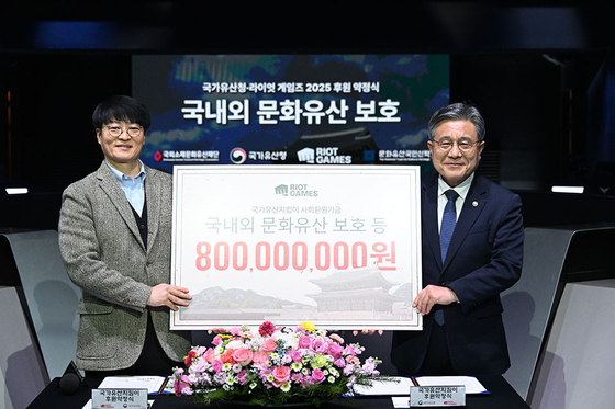 Riot Games Korea CEO Jo Hyuk-jin, left, poses with Korea Heritage Service Administrator Huh Min at an annual sponsorship agreement ceremony at the LoL Park in central Seoul on Dec. 2. [RIOT GAMES KOREA]