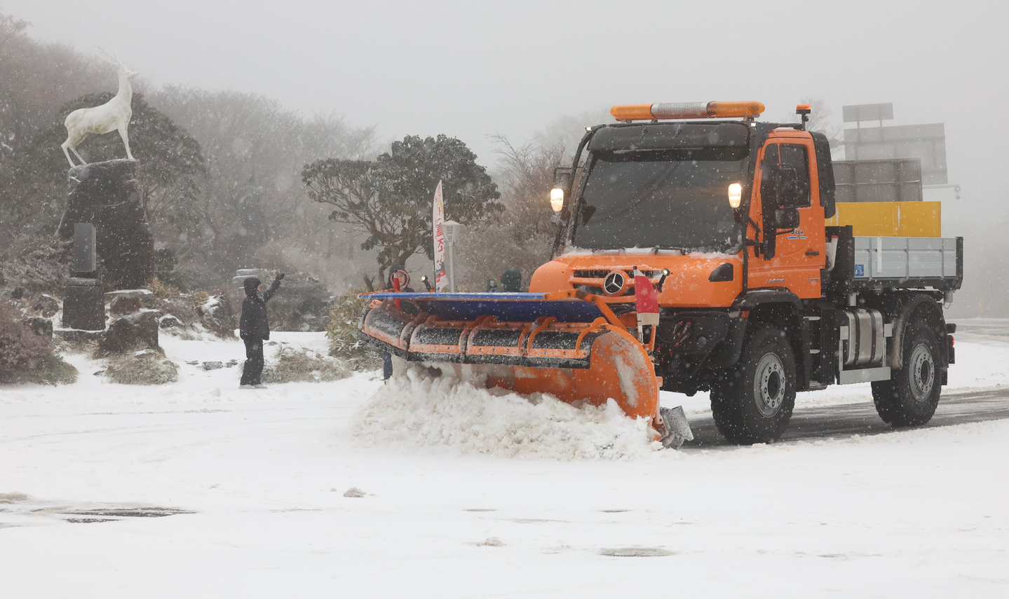 A snow removal vehicle is seen clearing snow from the road at the 1,100-meter (3,609-foot) high point of Mount Halla as a heavy snow advisory was issued for the Jeju Island mountainous region on Dec. 3. [YONHAP]
