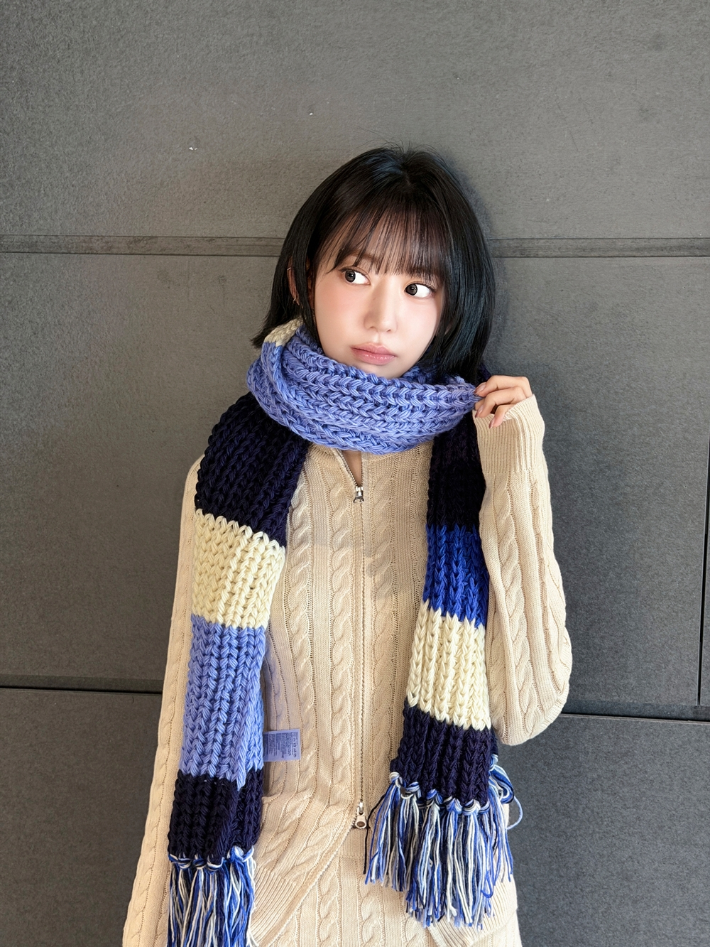 Sakura of girl group Le Sserafim wearing a muffler from her Kkurochet merchandise line [SOURCE MUSIC]