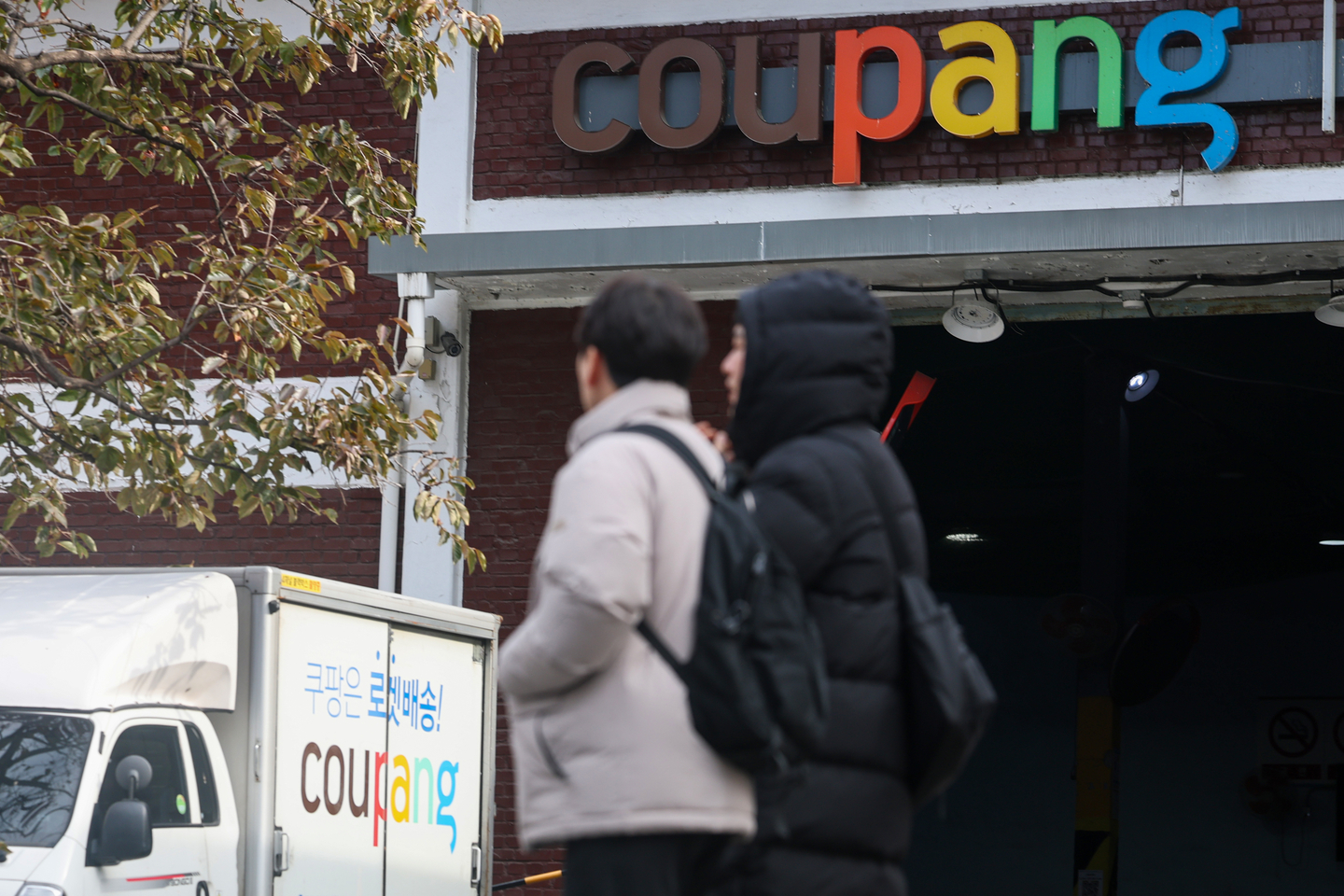 Pedestrians walk past a Coupang logistics center in Seoul on Dec. 2. [YONHAP]