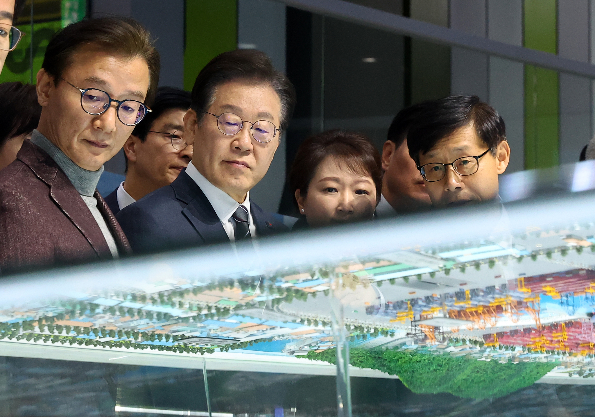 President Lee Jae Myung, who was then serving as Democratic Party leader, listens to a briefing on projected demand related to the opening of the Northern Sea Route during a visit to the Busan New Port promotion center in Gangseo District, Busan, on the morning of March 6. [YONHAP]
