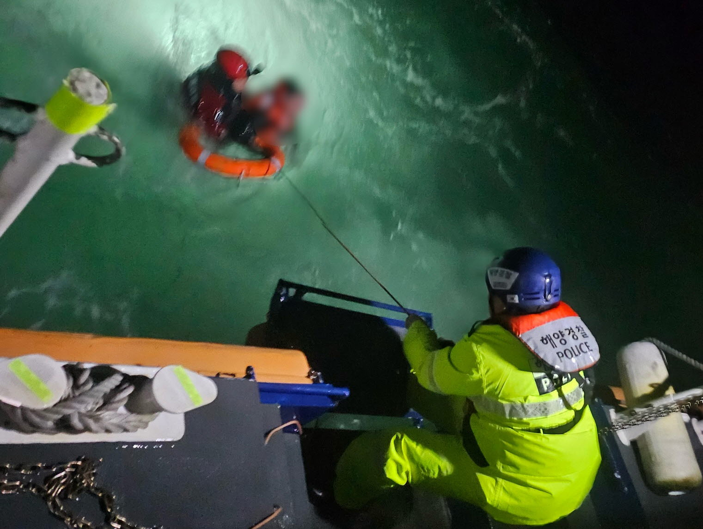 A Coast Guard officer rescues a crew member who fell into the sea after a fishing boat capsized near Cheollipo, Taean County, South Chungcheong, at around 6:20 p.m. on Dec. 4. [TAEAN COAST GUARD]