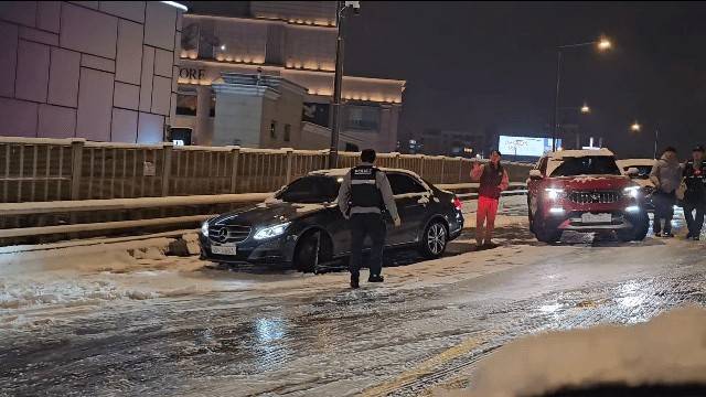 Vehicles come to a stop on an icy section of the Dongho Bridge overpass near Apgujeong Station in Gangnam District, southern Seoul, on Dec. 4, in this photo provided by a reader to Yonhap. [YONHAP]