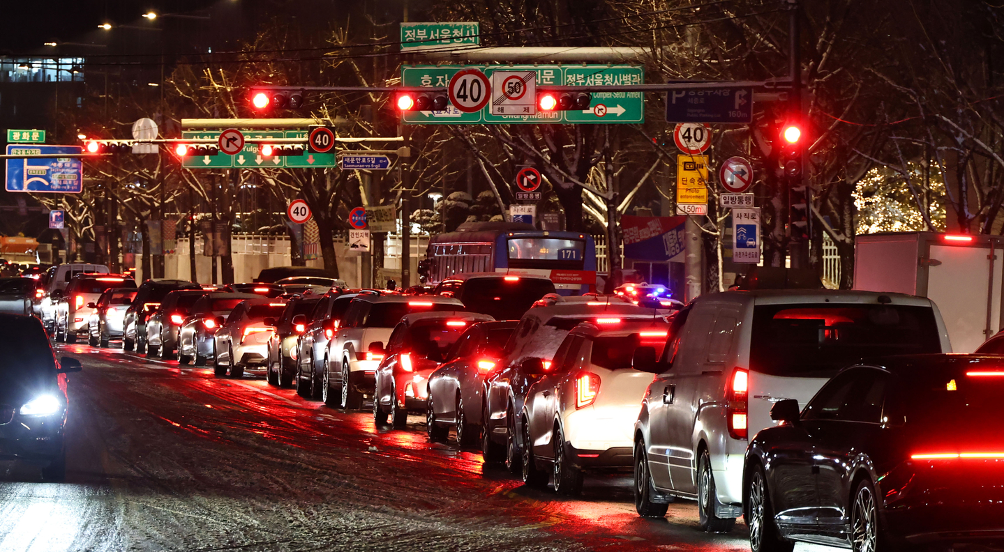 Roads near Gyeongbokgung Station in Jongno District, western Seoul, are congested due to heavy snowfall on Dec. 4. [YONHAP]