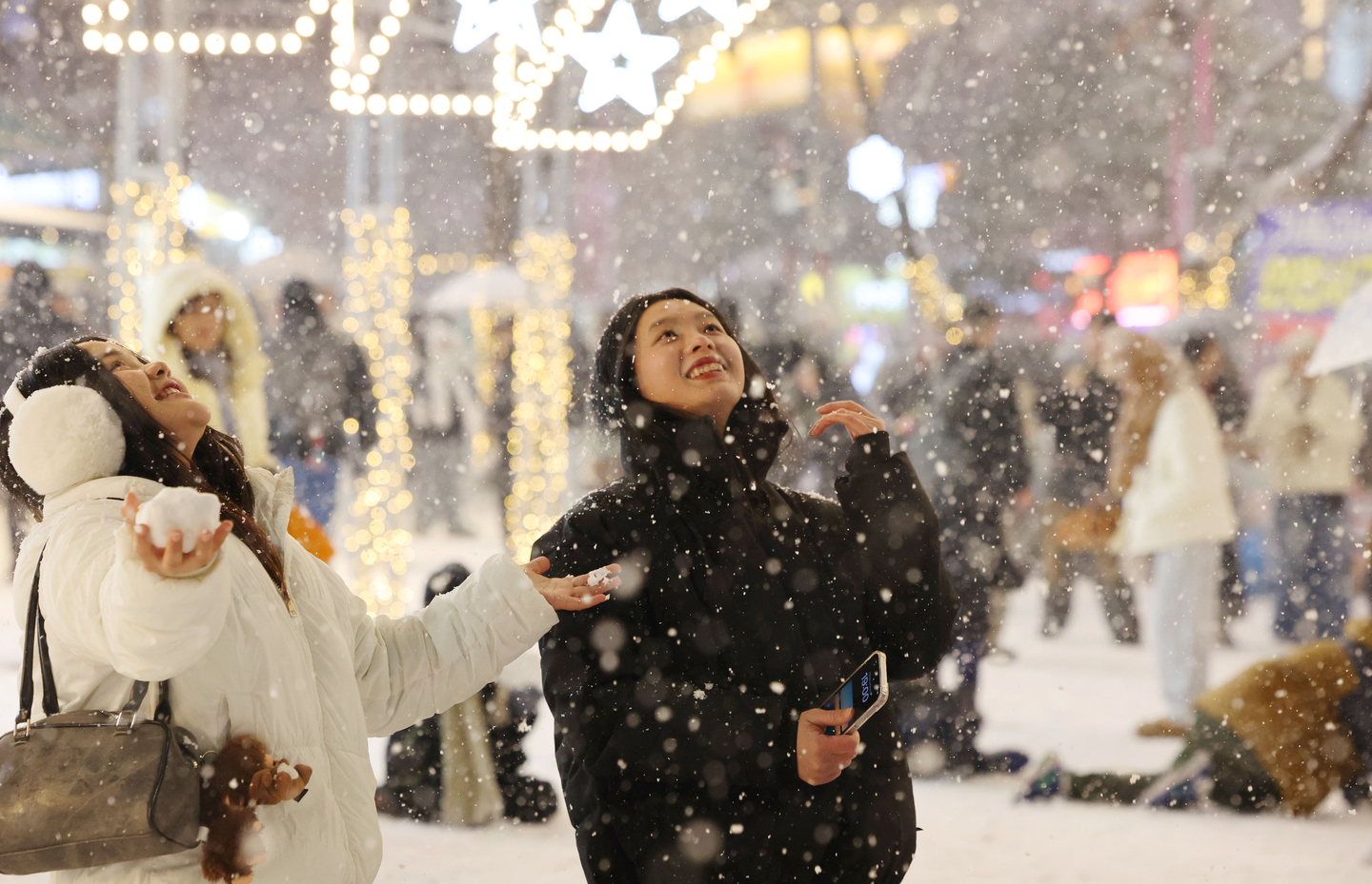 Tourists enjoy the snow near Hongdae in Mapo District, western Seoul, Dec. 4. [YONHAP]