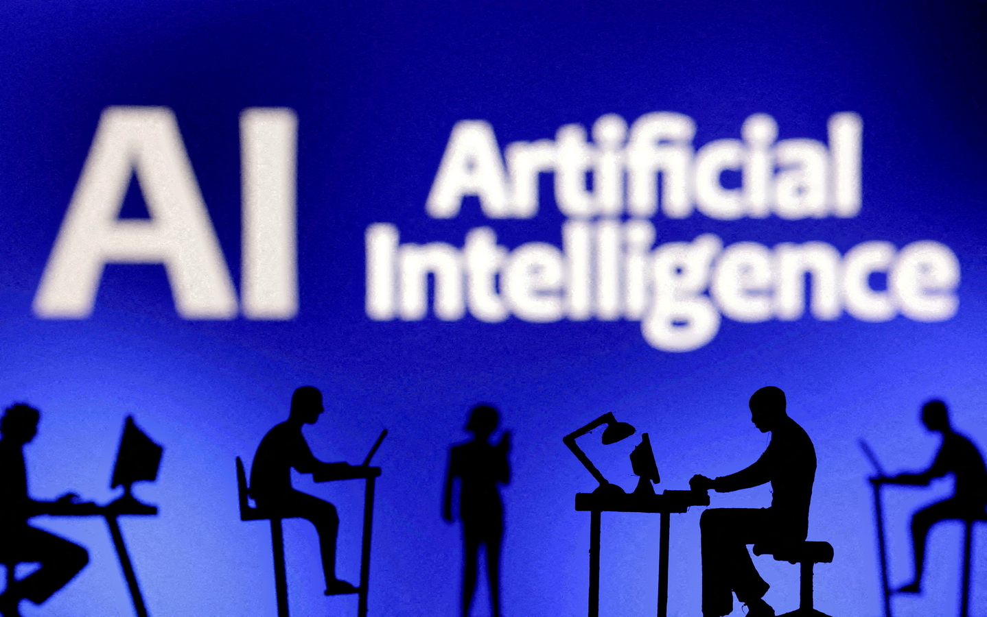 Figurines with computers and smartphones are seen in front of the words "Artificial Intelligence AI" in this photo of an illustration, taken on Feb. 19, 2024. [REUTERS/YONHAP]