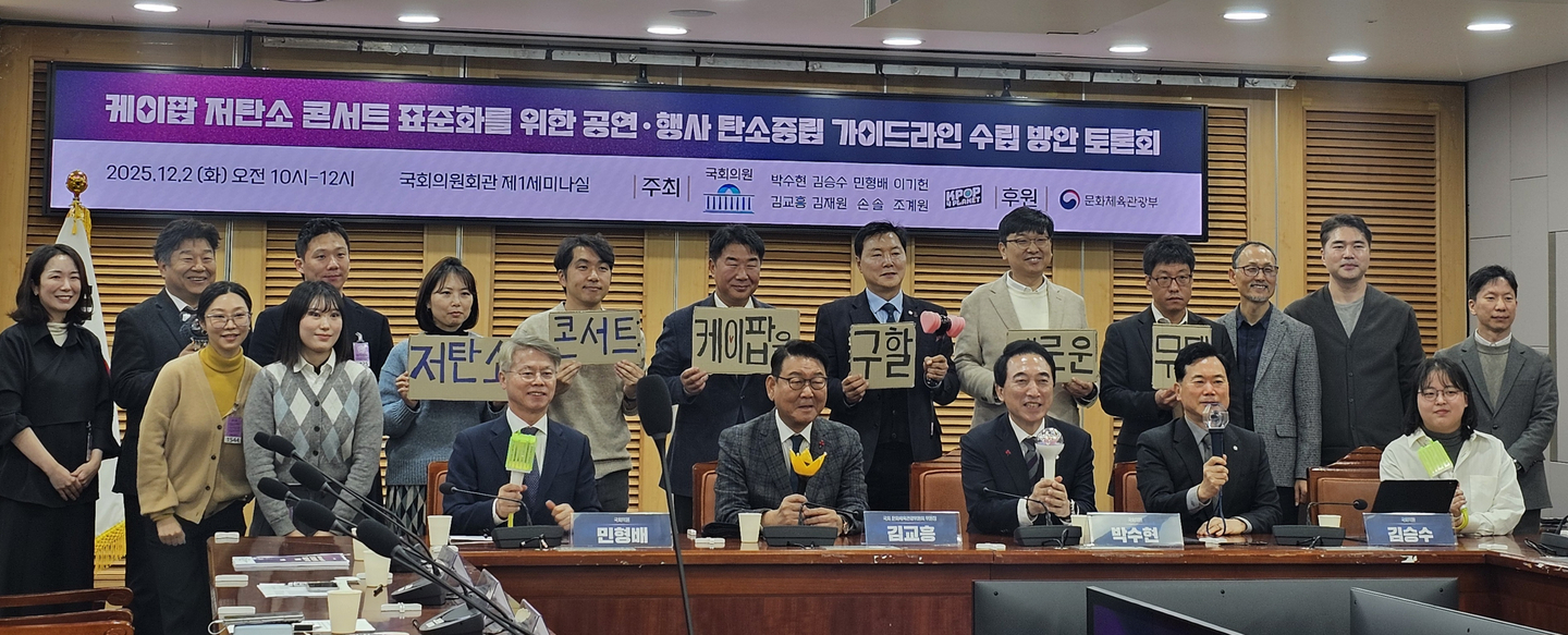 Lawmakers and presenters of a seminar on establishing carbon reduction guidelines for live performances pose for photos while holding K-pop light sticks at the National Assembly in western Seoul on Dec. 2. [SHIN HA-NEE]