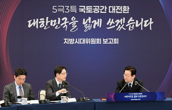 President Lee Jae Myung, right, listens as he receives a policy briefing from Kim Kyoung-soo, chair of the Presidential Committee for Decentralization and Balanced Development, at the Yongsan presidential office in central Seoul on Dec. 8. [JOINT PRESS CORPS]