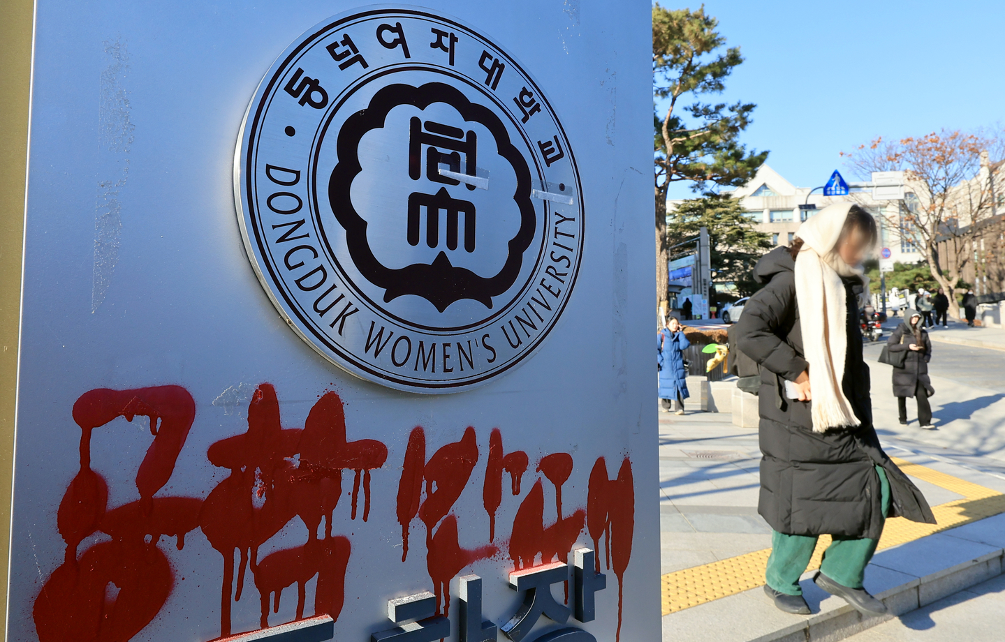 Graffiti opposing the decision by Dongduk Women's University to go co-ed is seen on a sign at the school's campus in Seongbuk District, northern Seoul, on Dec. 4. [NEWS1]