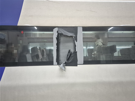 Tape and a torn piece of fabric cover a broken exterior window on KTX 215 bound for Masan Station in Changwon, South Gyeongsang, from Seoul on Dec. 8. [JOONGANG ILBO]