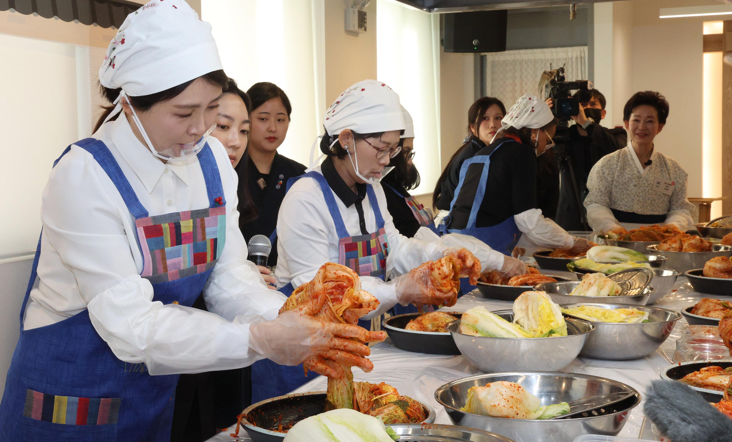 First lady Kim Hea Kyung, left, makes kimchi with spouses of ambassadors to Korea during a kimjang event teaching the traditional process of making kimchi in central Seoul on Dec. 9. [JOINT PRESS CORPS]