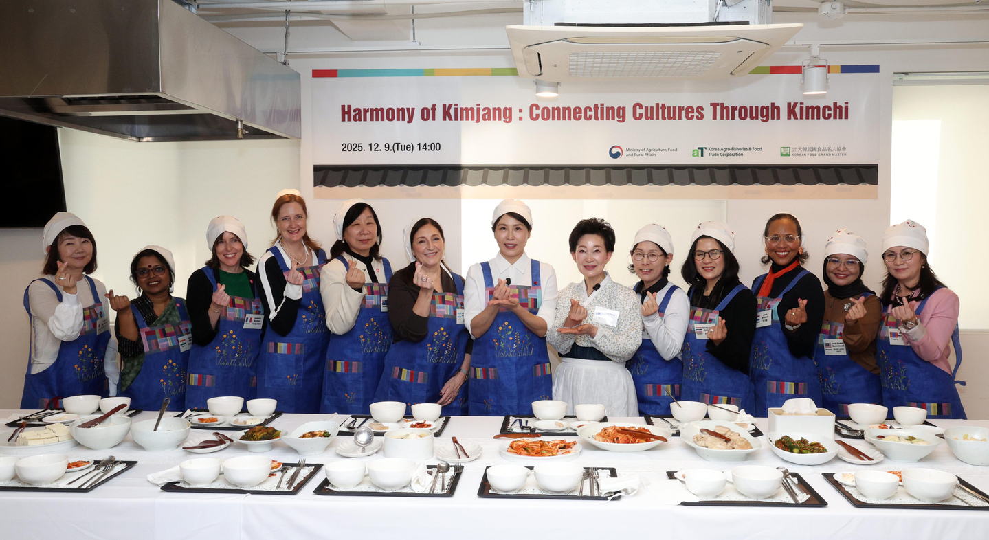 First lady Kim Hea Kyung, center, takes a commemorative photo with spouses of ambassadors to Korea during a kimchi-making event in central Seoul on Dec. 9. The event was attended by the spouses of the ambassadors of Argentina, Australia, Britain, Canada, France, India, Japan, Malaysia, Mongolia, the Netherlands and Thailand. [JOINT PRESS CORPS]