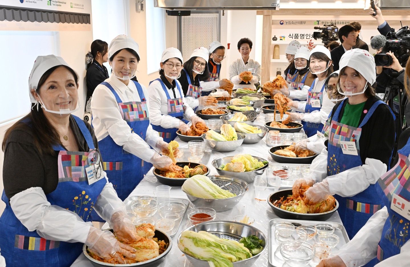 First lady Kim Hea Kyung, second from left, takes a commemorative photo with spouses of ambassadors to Korea during a kimchi-making event in central Seoul on Dec. 9. The event was attended by the spouses of the ambassadors of Argentina, Australia, Britain, Canada, France, India, Japan, Malaysia, Mongolia, the Netherlands and Thailand. [JOINT PRESS CORPS]