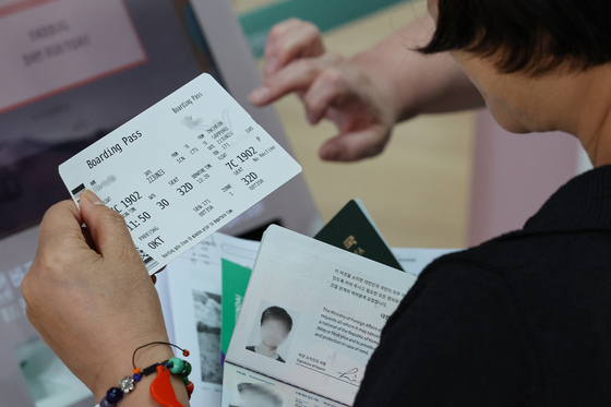 A customer checks their airplane ticket to Sapporo at the INcheon International Airport in Incheon on June 22, 2023. [YONHAP]