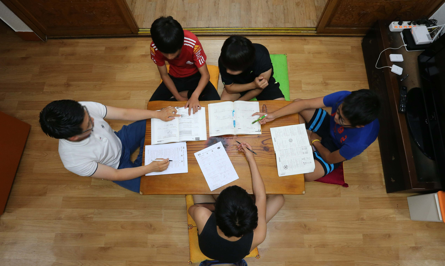 A volunteer, left, teaches adolescents placed at a youth recovery center in Changwon, South Gyeongsang. The center provides care and support for teenagers entrusted to it under the Juvenile Act, helping them adjust to society. [JOONGANG ILBO]