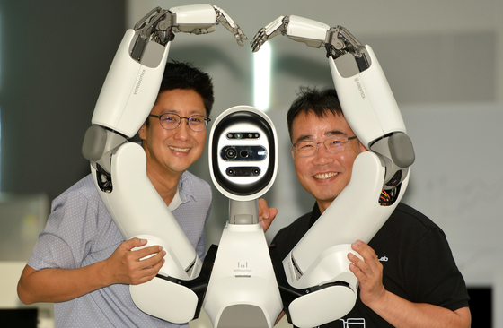 WIRobotics executives pose with its humanoid robot, Allex, in Cheonan, South Chungcheong, on Aug. 19. [KIM SUNG-TAE] 