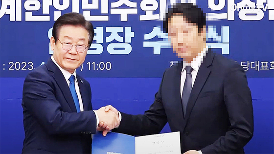Lee Jae Myung, then leader of the Democratic Party, right, presents an appointment certificate in April 2023 to Lee, former director of missionary policy at the Unification Church, naming him a vice chair of the party’s association for overseas Koreans. [SCREEN CAPTURE]